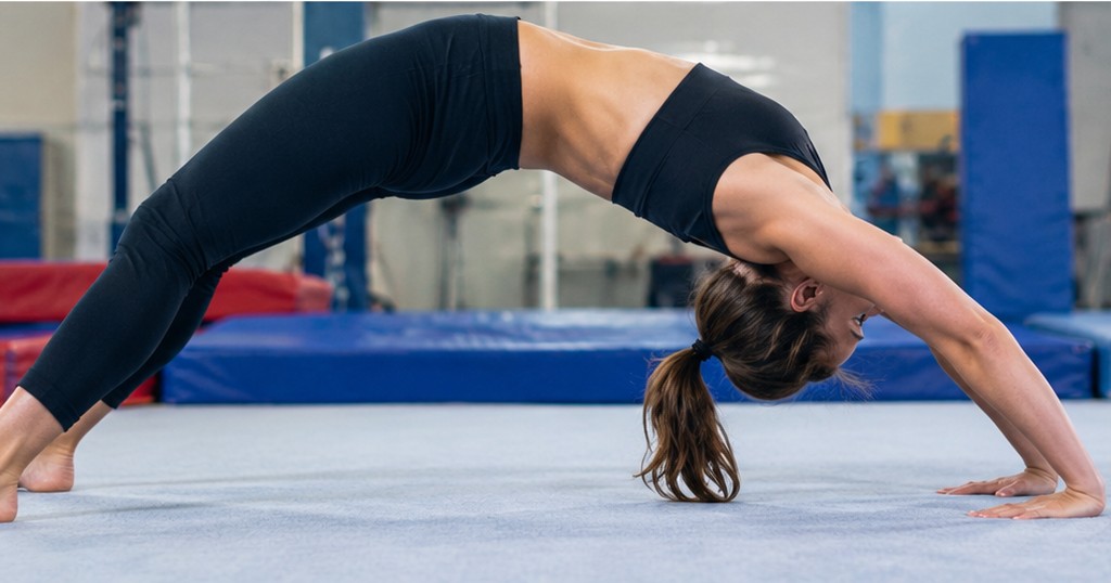 Gymnast performing a bridge pose stretch, demonstrating spinal and shoulder flexibility