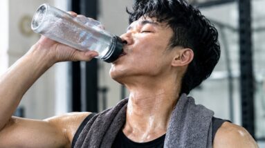Man drinking water after an intense CrossFit workout, sweaty and recovering