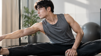 "Man stretching his hamstring on a yoga mat during a post-workout recovery routine"