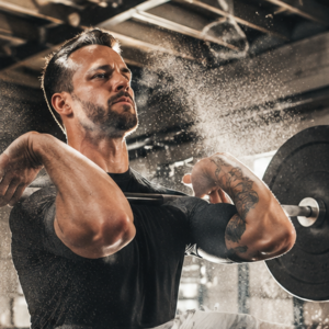 An athlete performing a barbell clean in a modern functional fitness box gym.